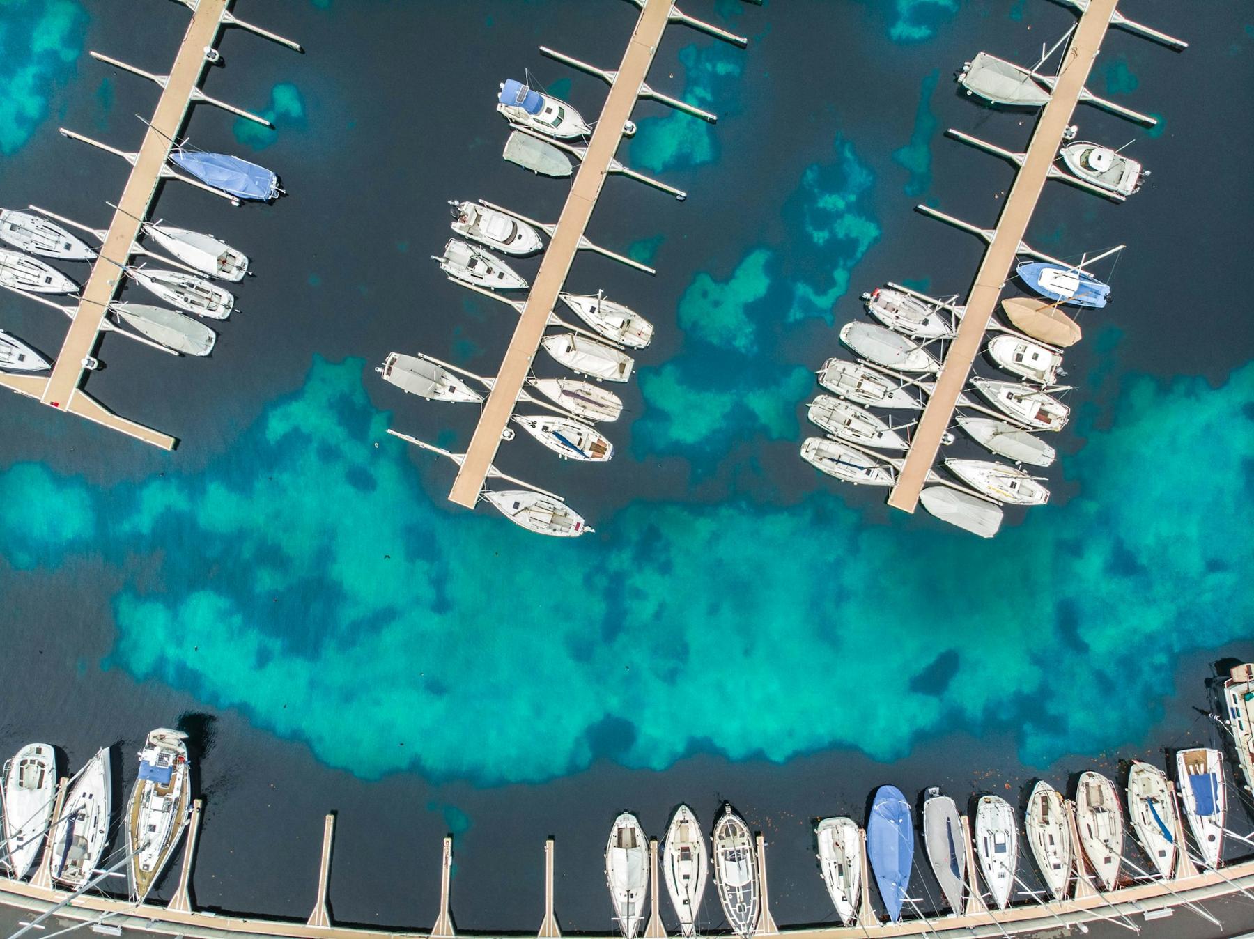 Aerial view of a marina with boats in slips over turquoise water